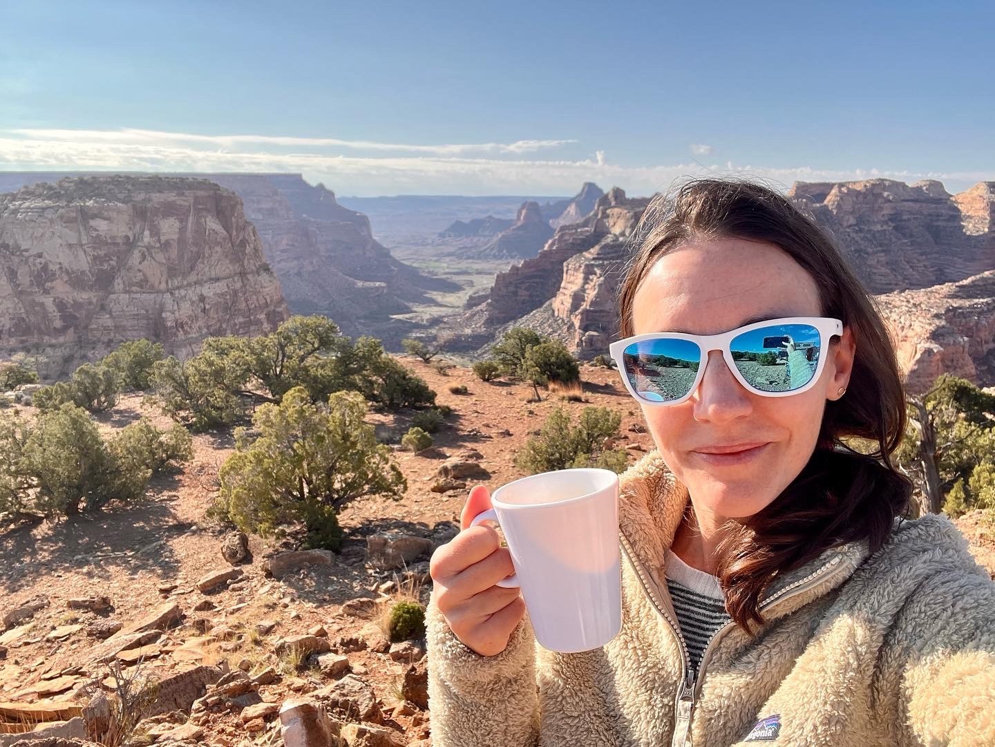 Woman with coffee overlooking a canyon