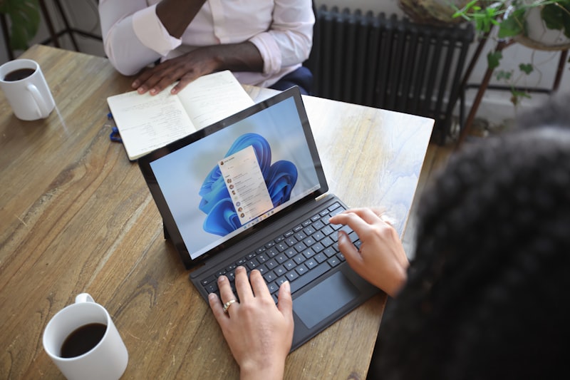 Professionnel prenant des notes sur un ordinateur portable lors d'une réunion de travail — rédaction de PV CSE