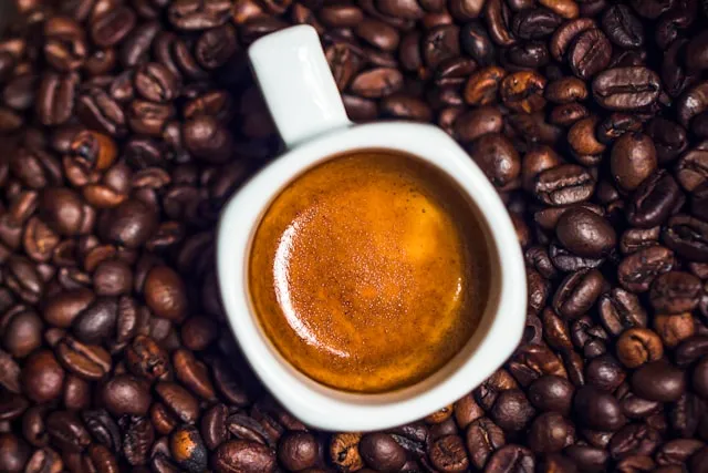Cup of coffee with on the coffee beand background