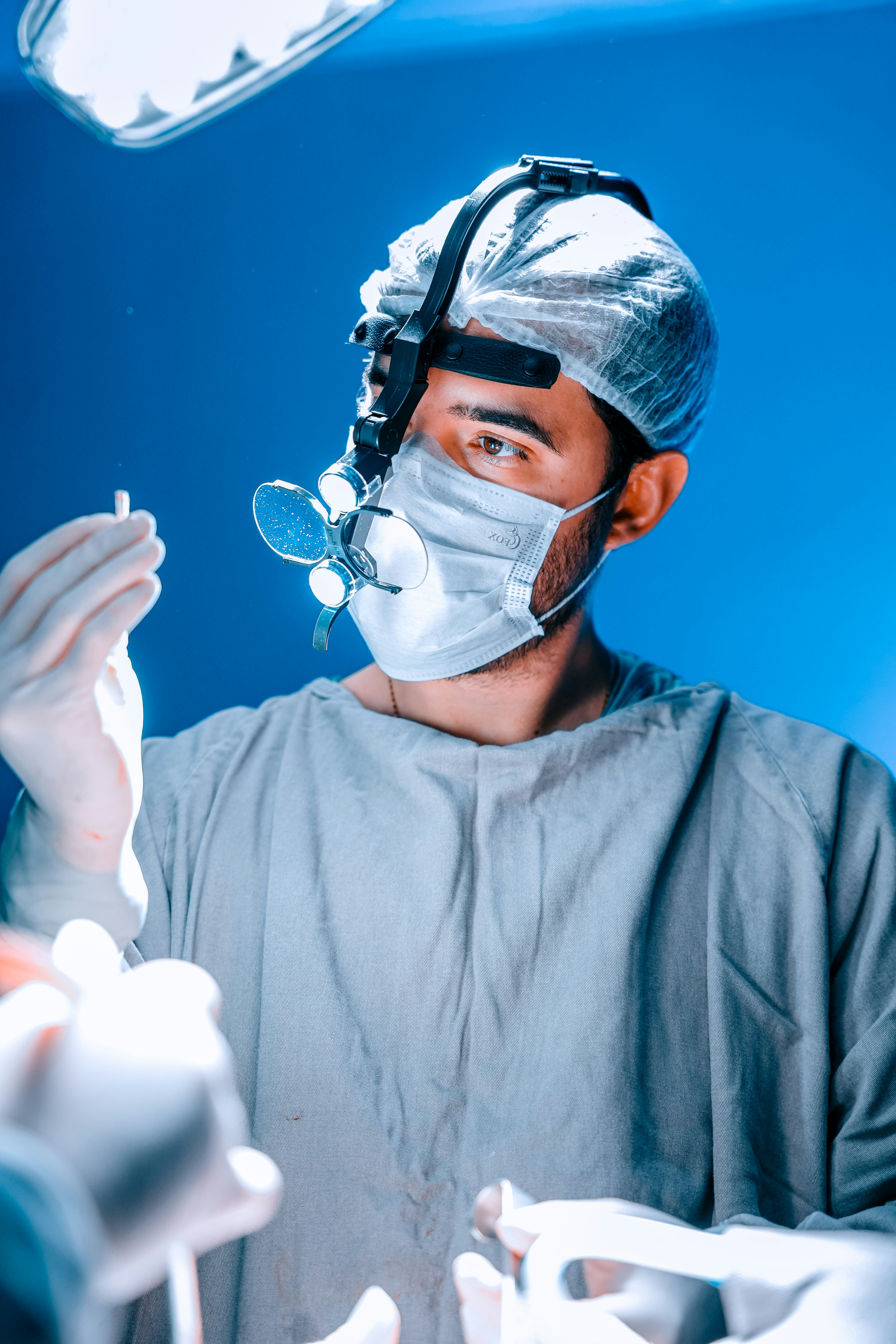 A surgeon examines a medical instrument during surgery.
