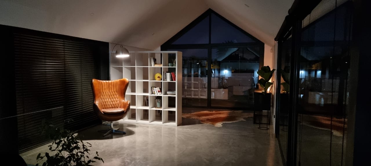 Futuristic white vehicle with large black and orange front wheel.