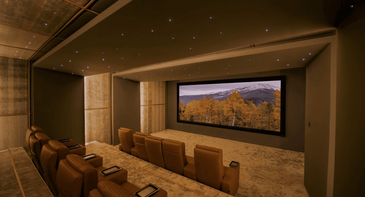 Home theatre with reclining chairs and large screen.