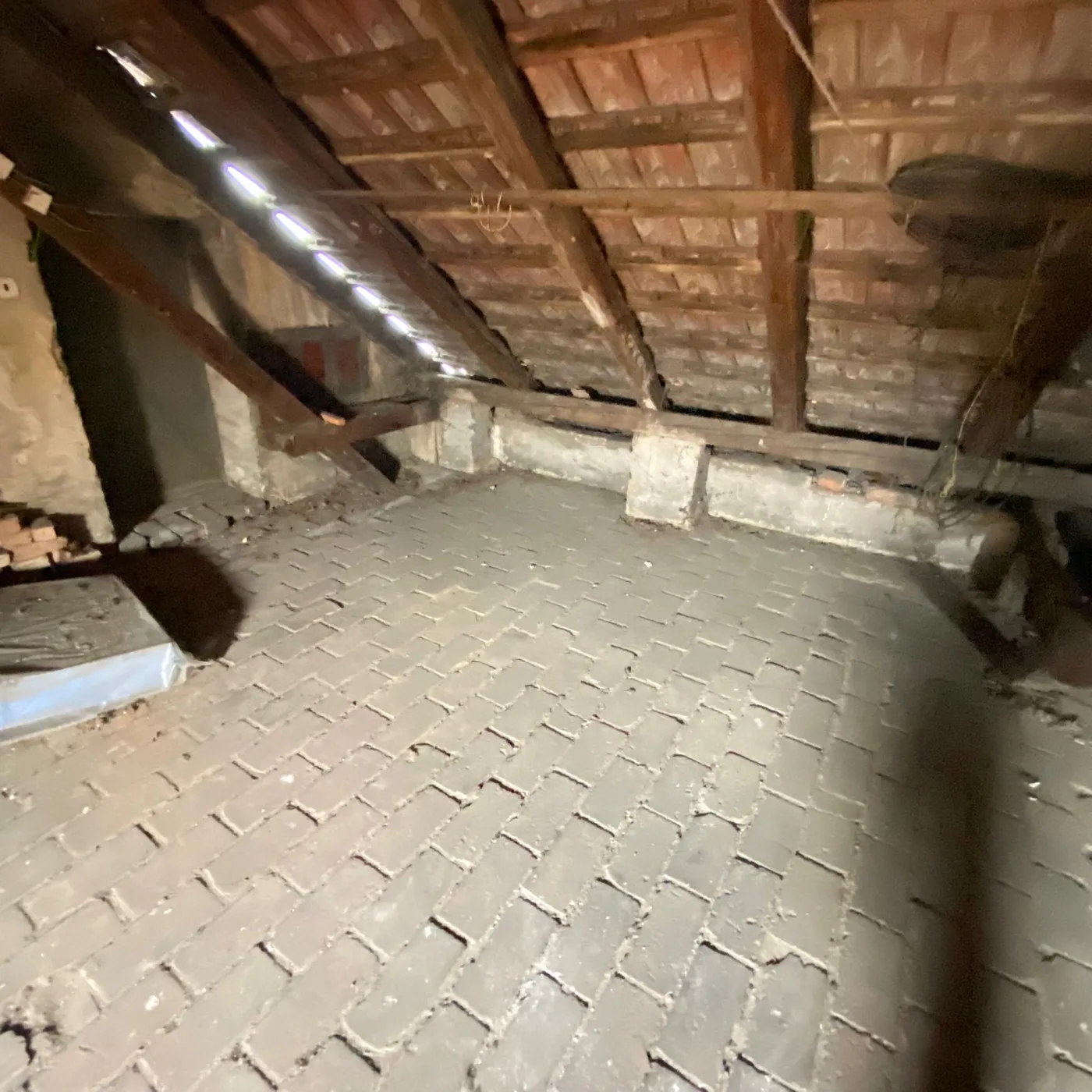 Skutečný půdní prostor s dřevěnými trámy a cihlovou podlahou