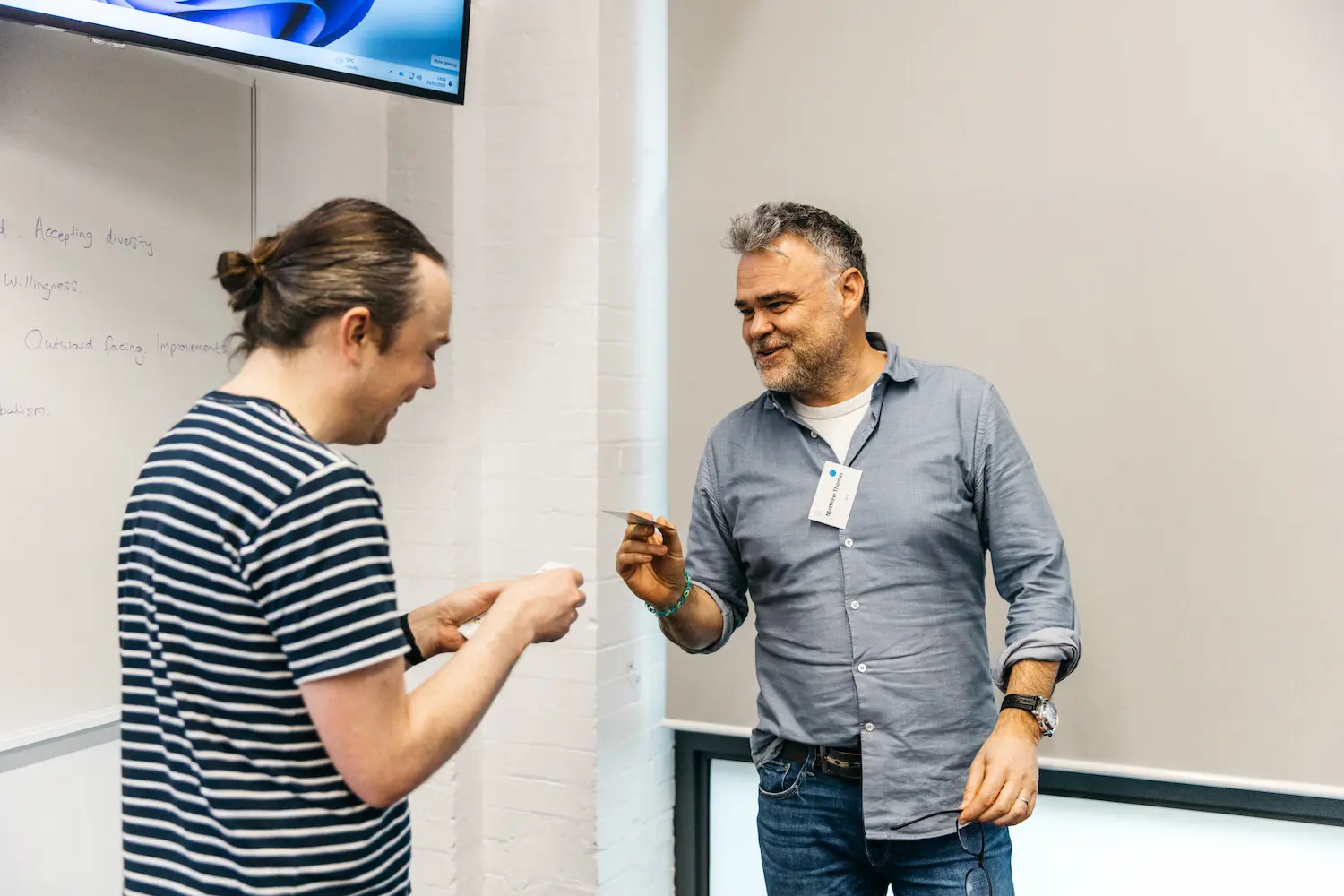 Two people talking with a projector in an art gallery.