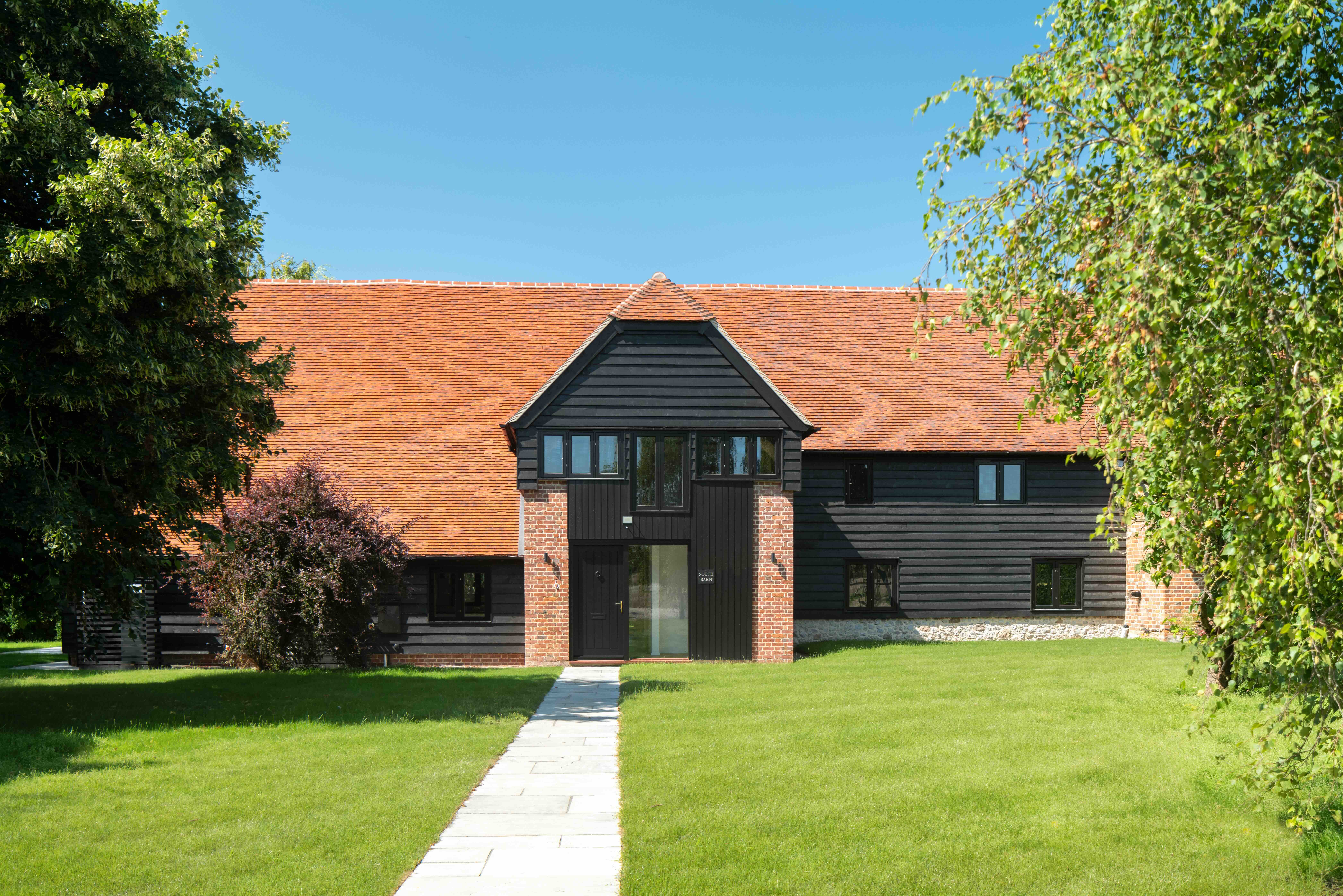     External view of oak-framed barn reconstruction, re-establishing the character of a historic agricultural building in Oxfordshire