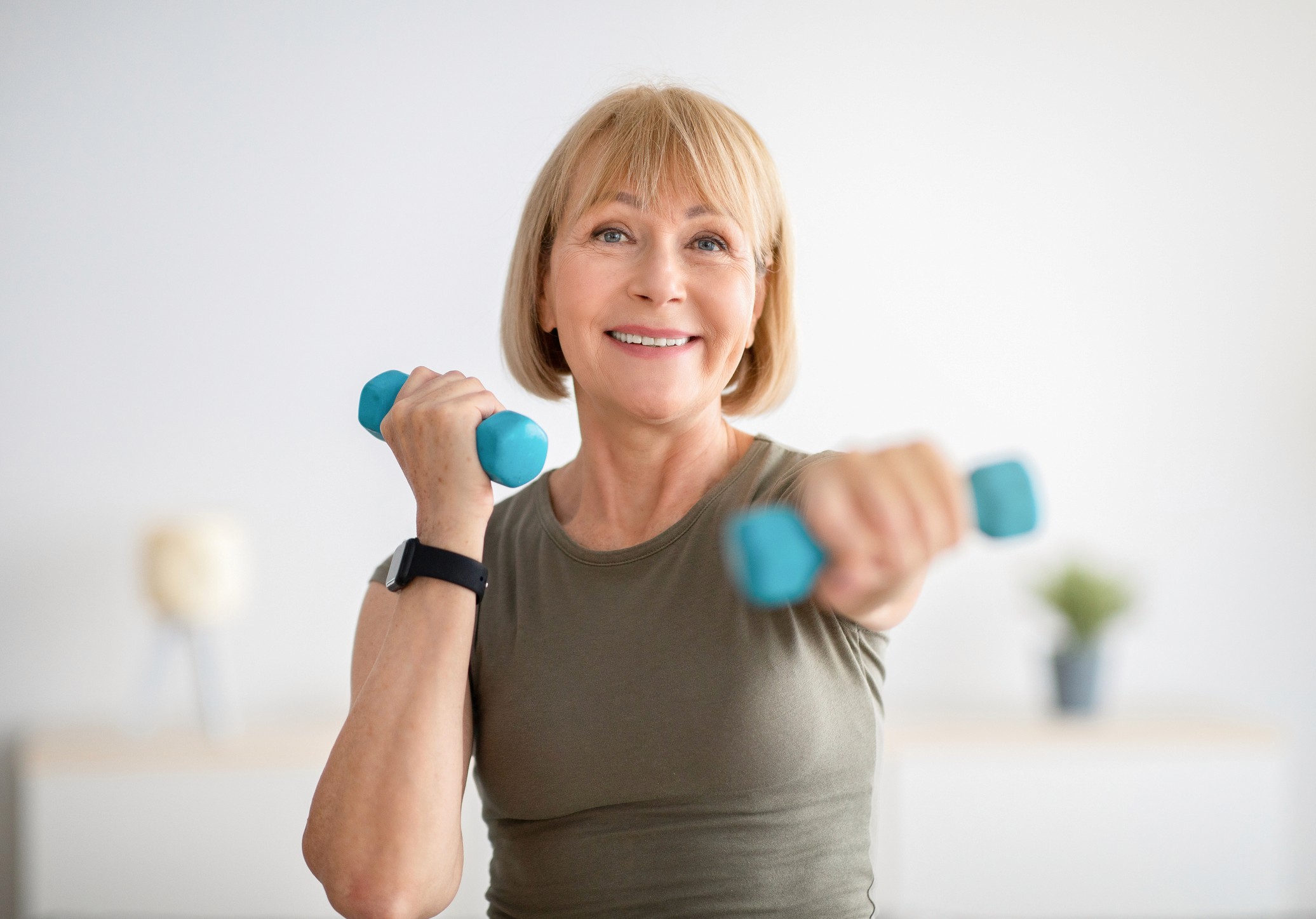 Woman exercising with blue hand weights