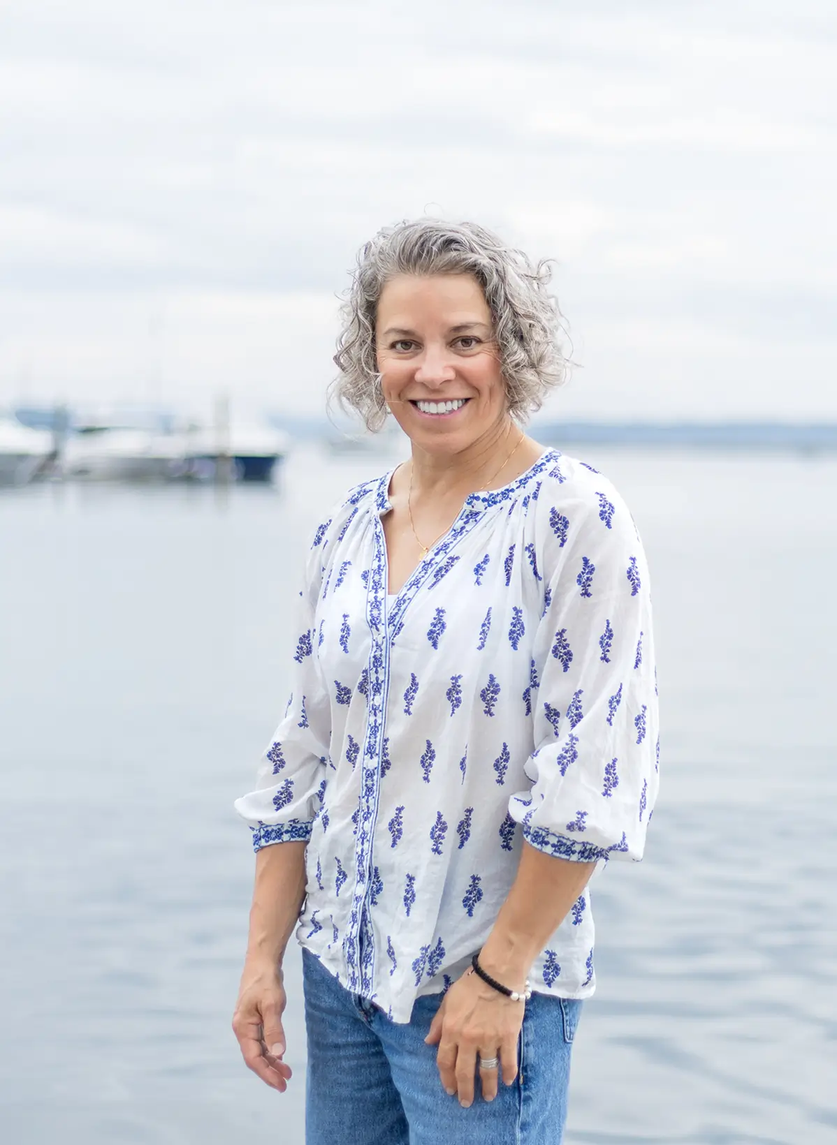 Headshot photo of Julie Roick standing in front of a ocean