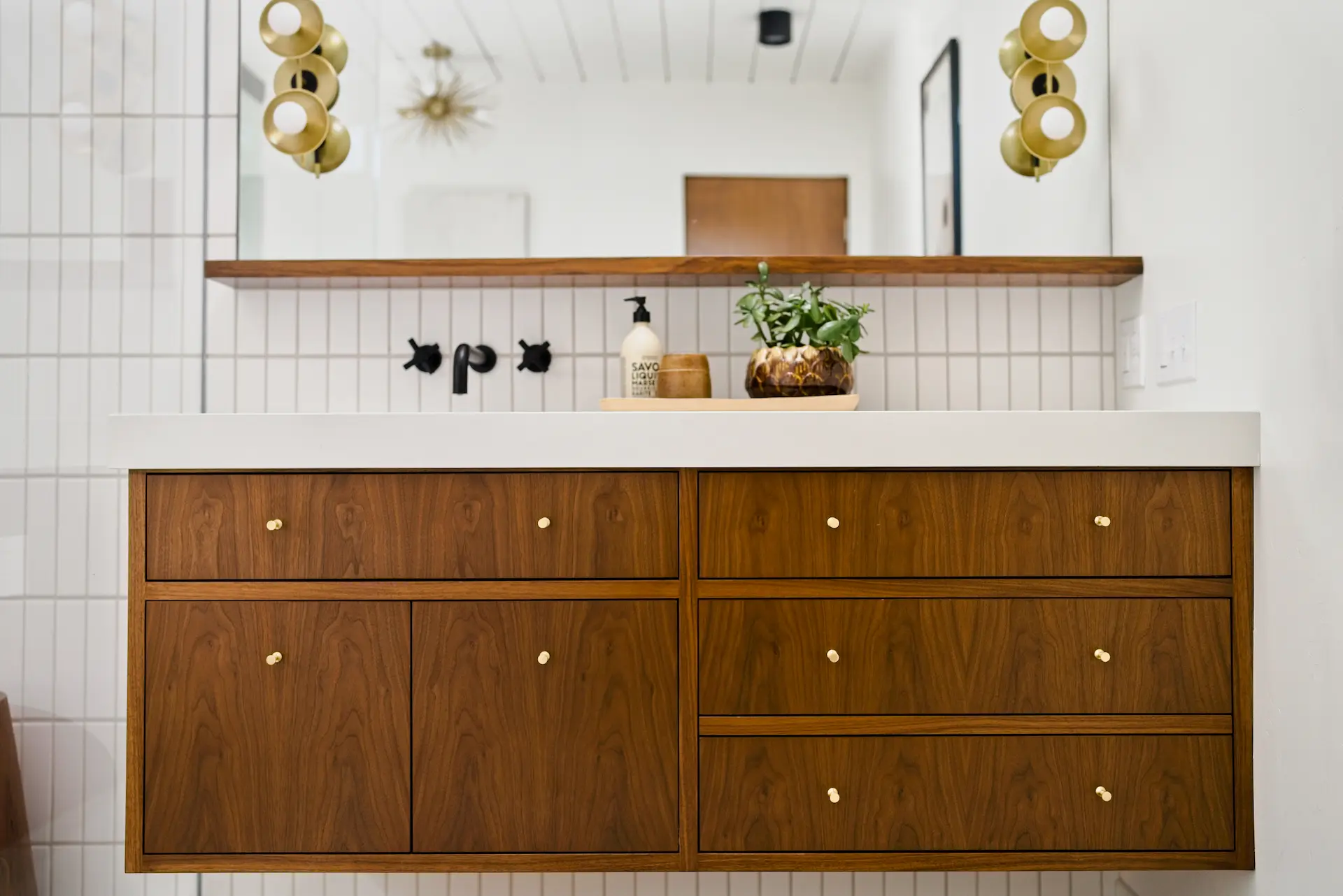 Close-up view of the floating vanity in the primary bathroom, highlighting the sink and storage design in the Fairhaven Eichler Tract remodel. Photo by Todd Huge.