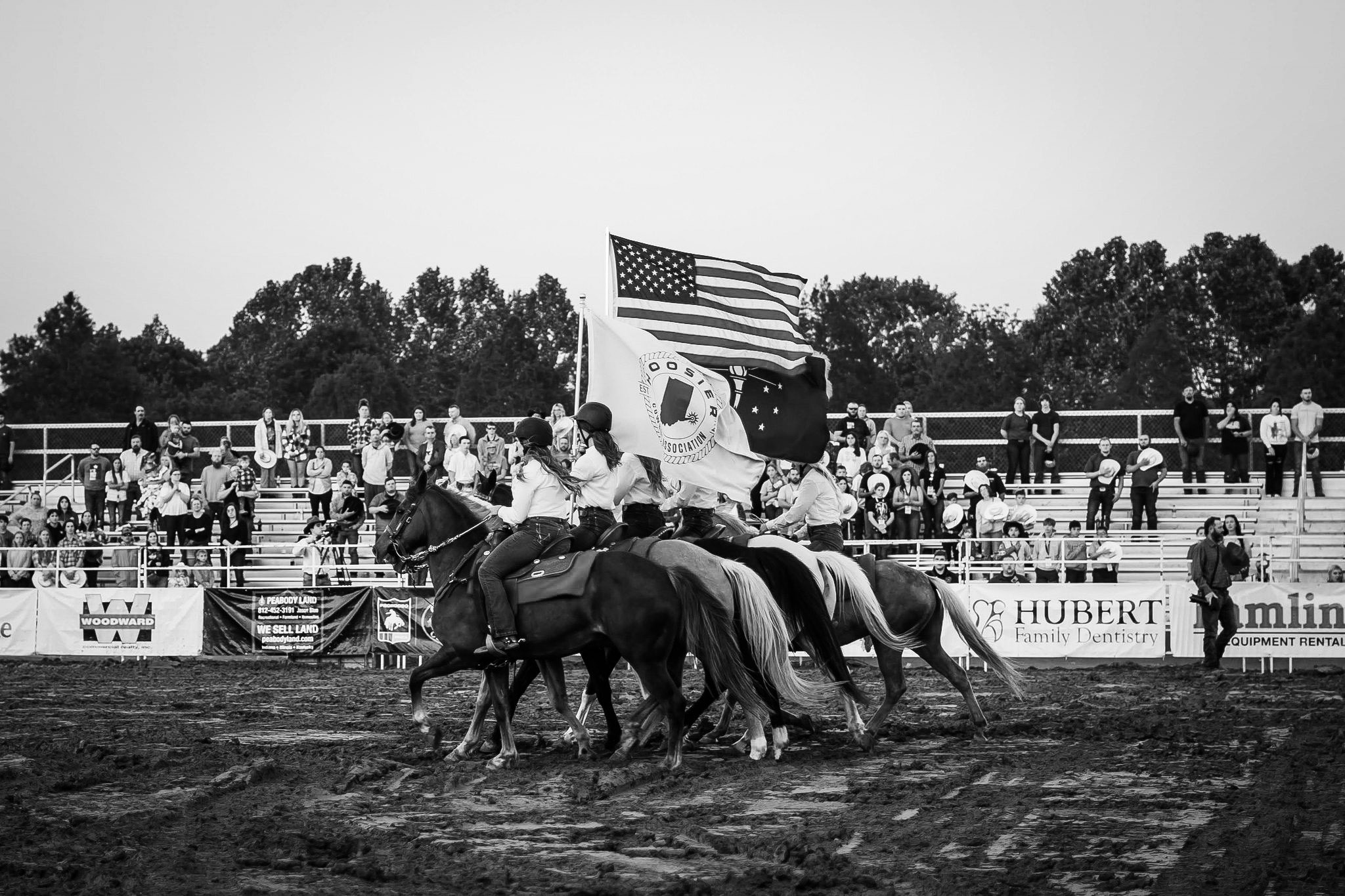 Horse riders carrying flags around HCA rodeo arena 