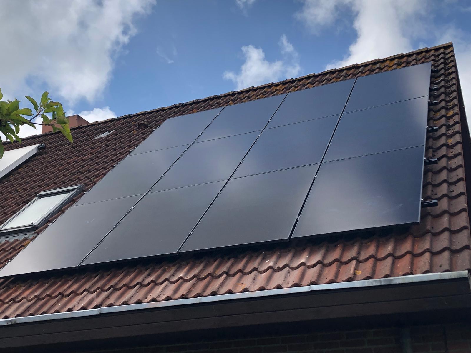 brown brick house with solar panels on roof