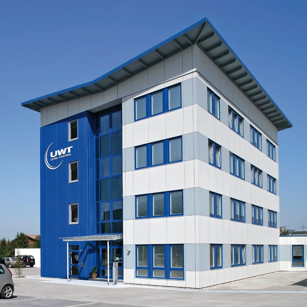 Moderne Bürofassade mit UWT Level Control Logo, blau-grauer Verkleidung und großen Fenstern.