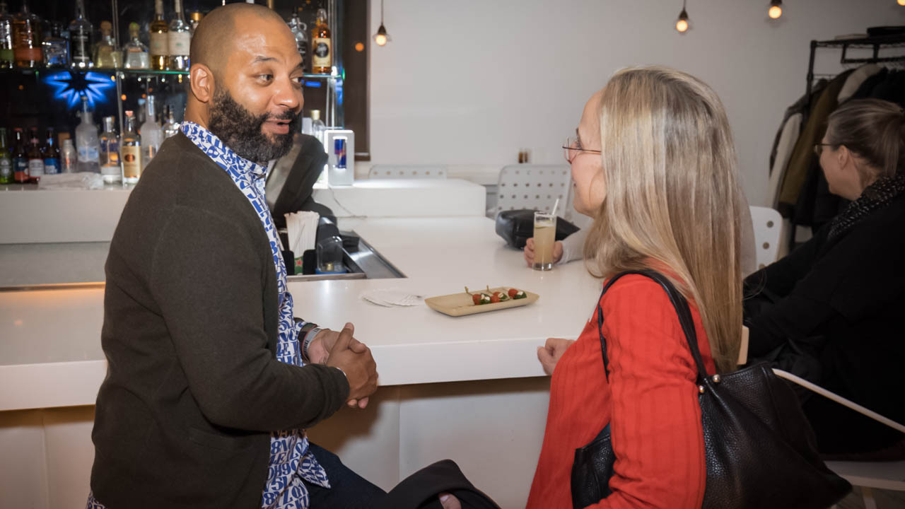 two people talking at a bar