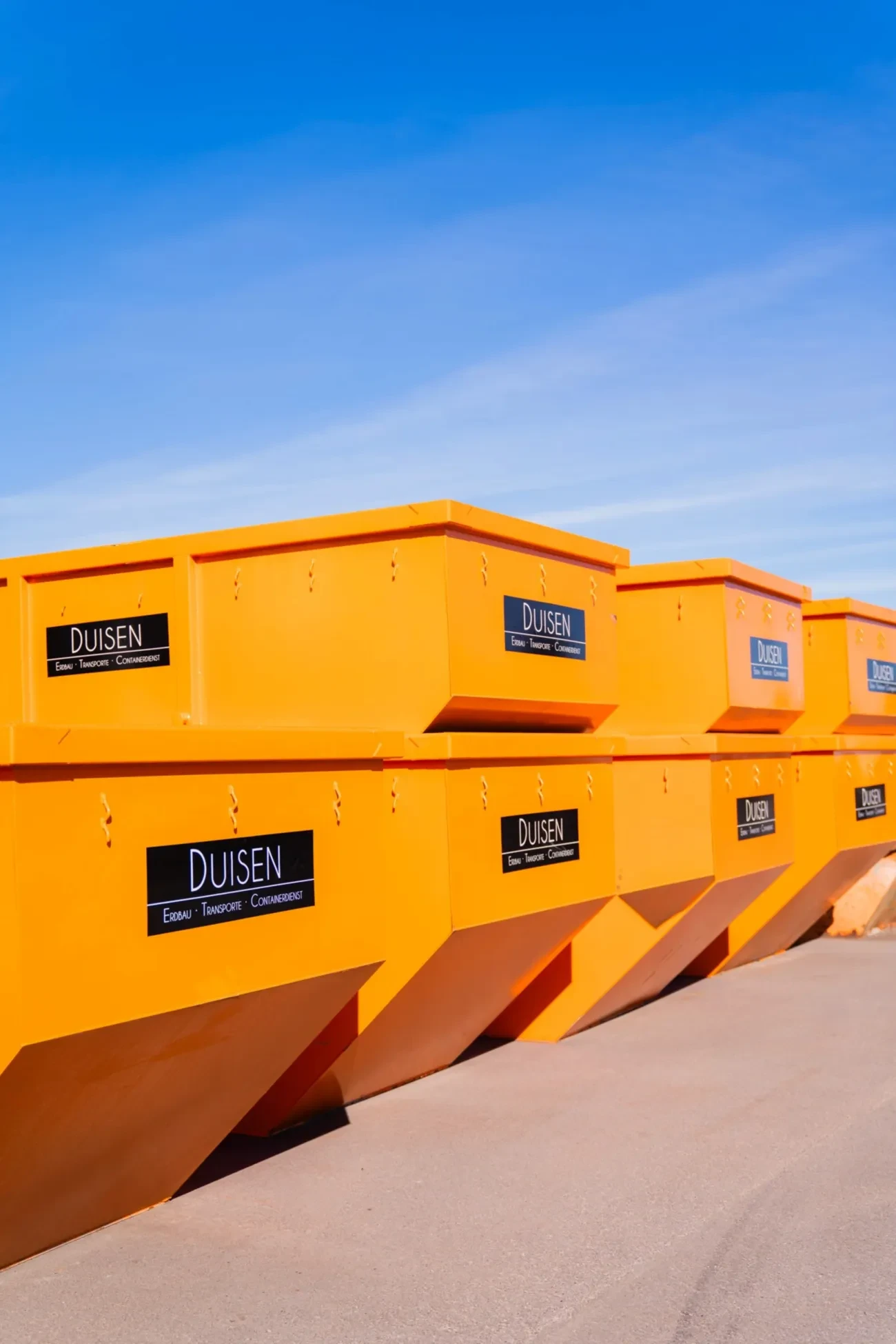 Mehrere orange Absetzcontainer „Duisen“ aufgereiht auf dem Betriebshof