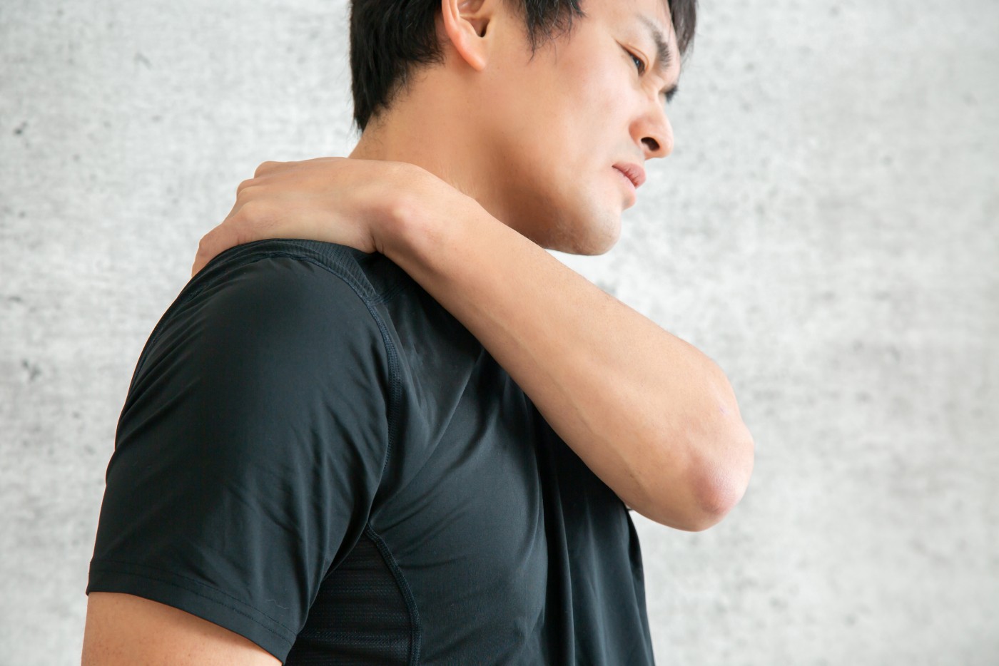 肩甲骨を押さえる男性