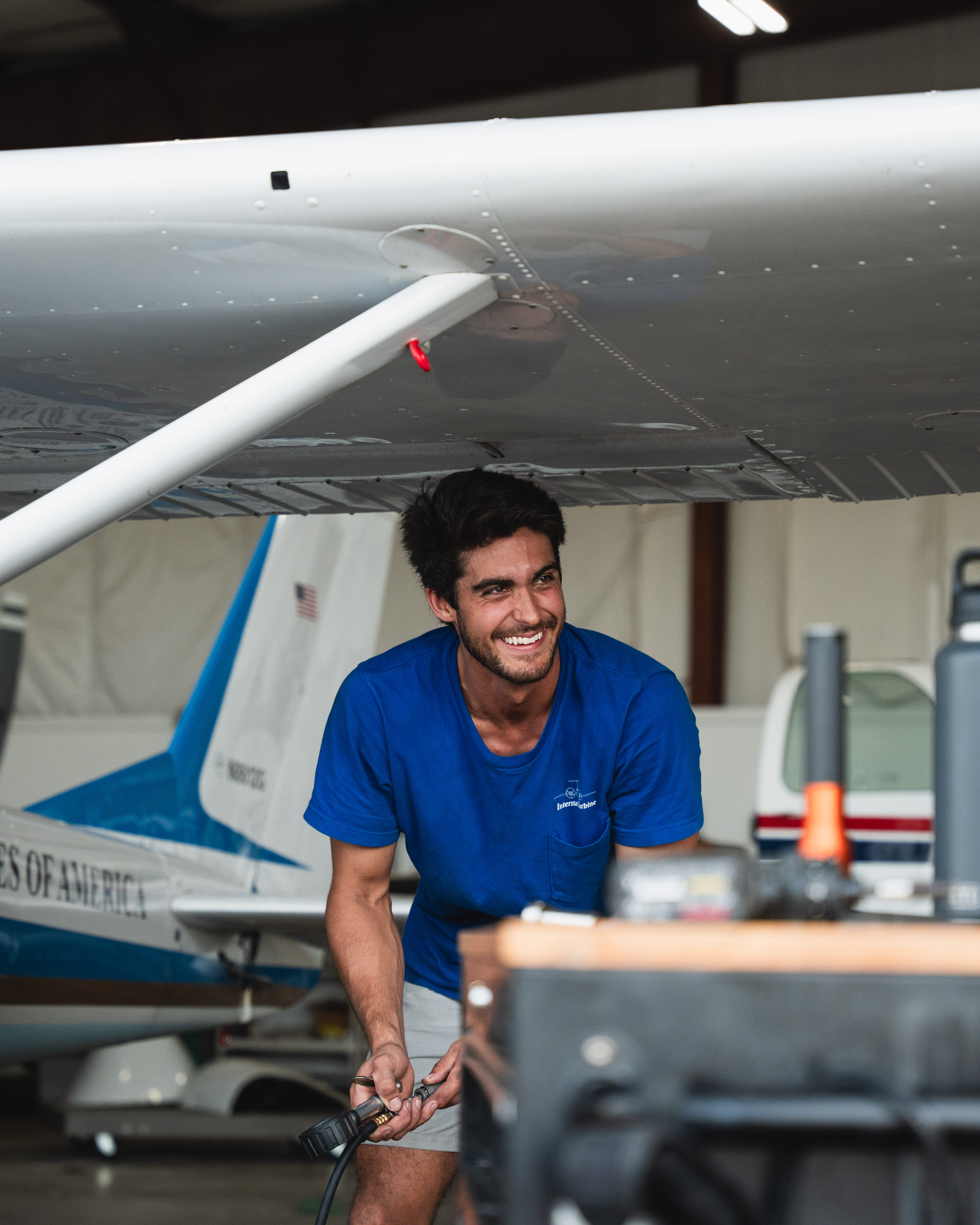 Two colleagues smiling and collaborating at a laptop in a bright office.