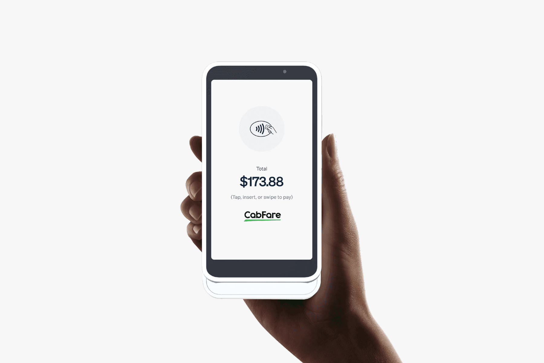 A man driving a car. He is wearing a grey sweater and is looking at the camera with a slight smile.