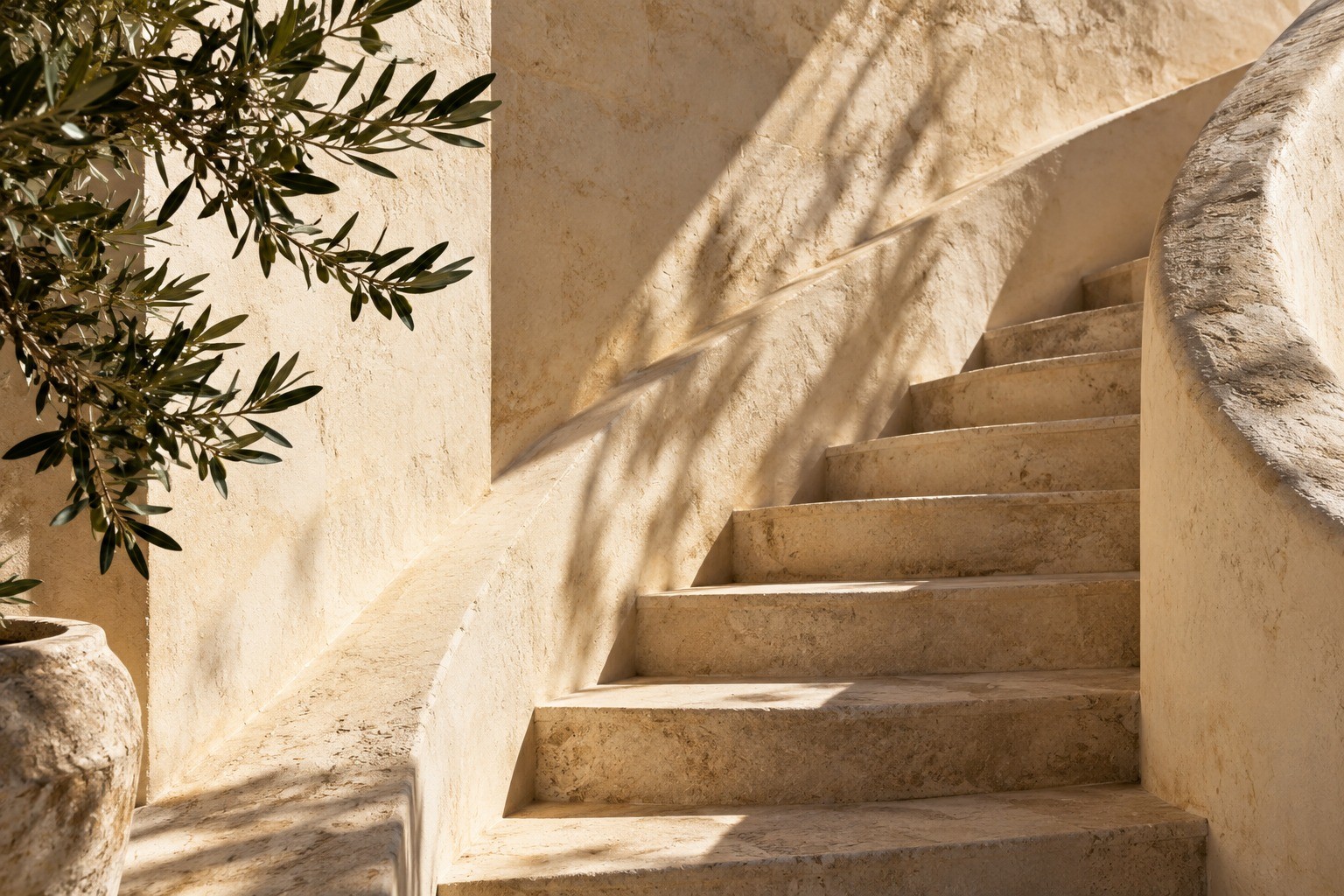 Curved limestone staircase with olive branch shadows