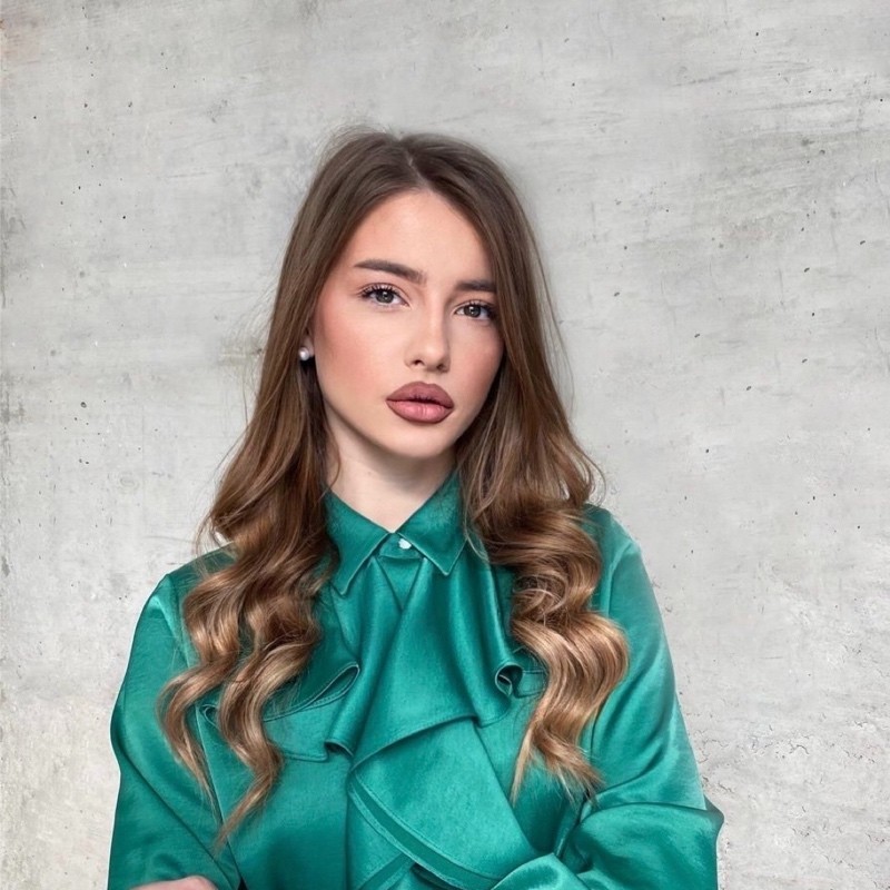 Profile portrait of a man in a white shirt against a light background