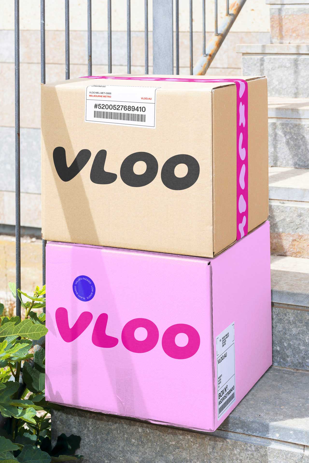 Packaging design: Cardboard delivery boxes featuring the VLOO logo and packing tape with VLOO's organic shapes, emphasising low-waste packaging practices.