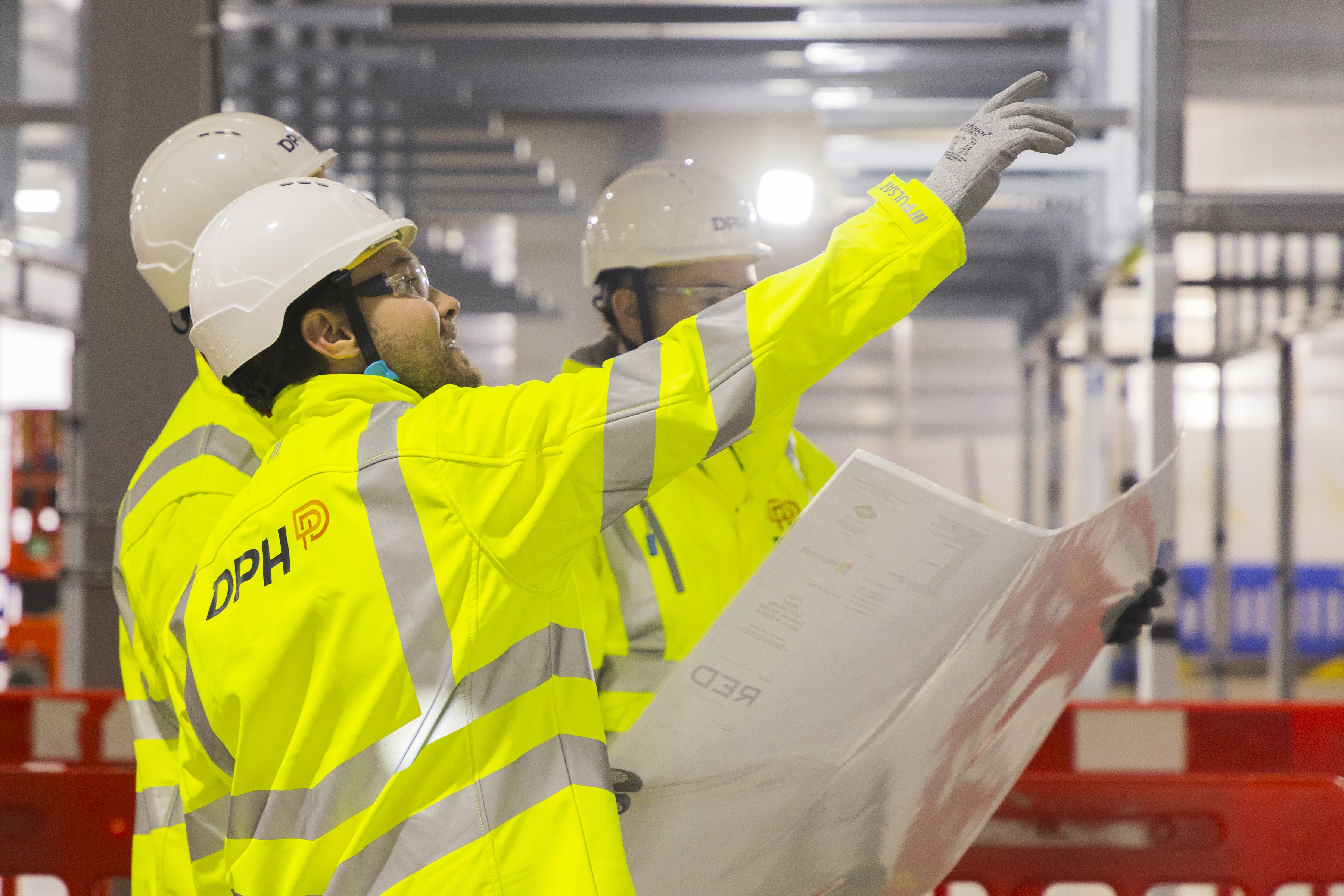 Modern glass building with illuminated trees and a view of city skyscrapers