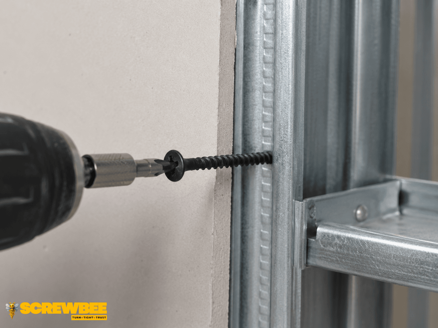 Black Zinc Drywall Screw being installed into gypsum board and light-gauge metal framing