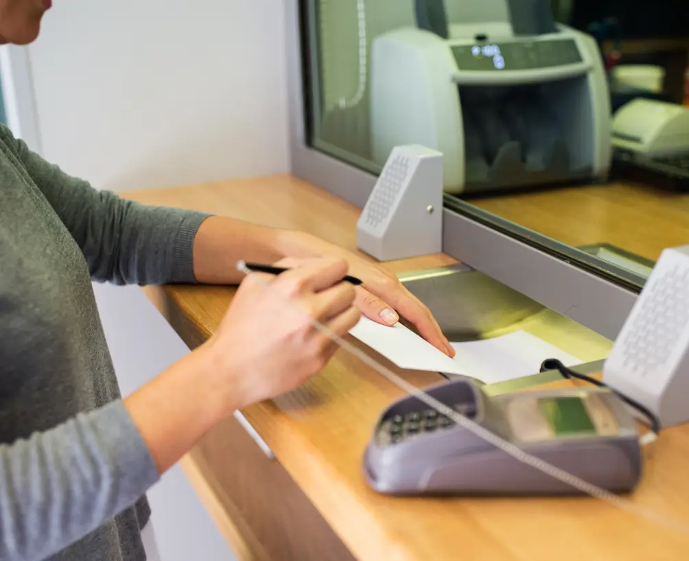 Bank cleaning professional disinfecting teller counter surfaces in a financial institution lobby