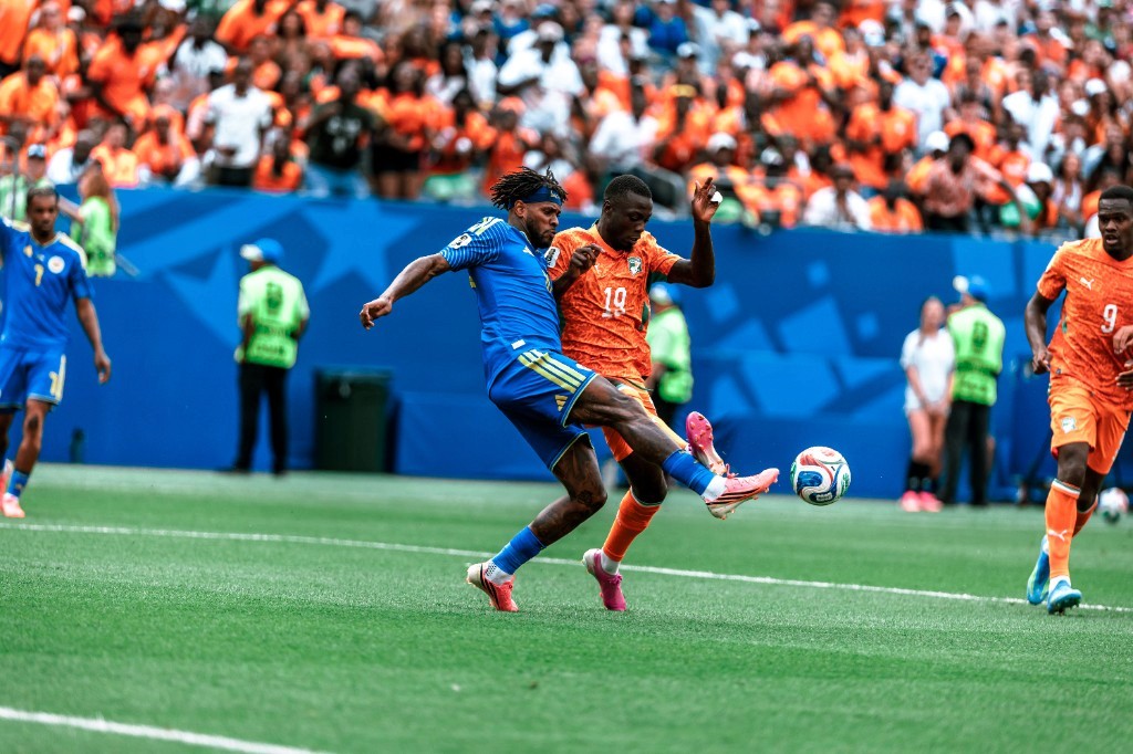 A Curaçao player heads the ball under pressure from Ivory Coast's number 9 during their World Cup Group E match