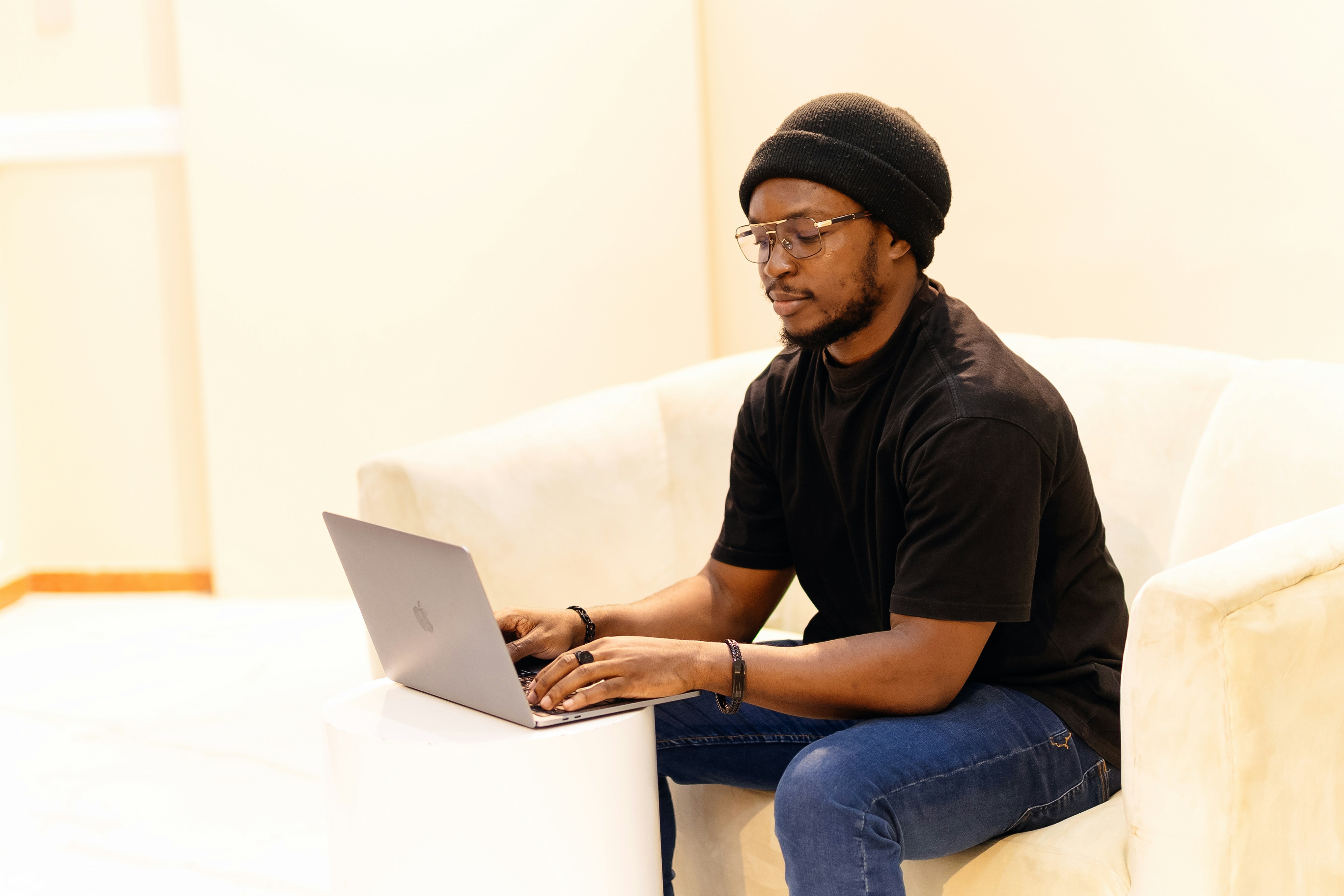 A man sitting on a couch using a laptop computer