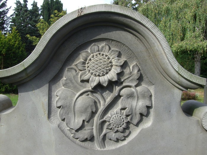 Sonnenblumen als Relief im Bogenfeld eines Grabmals