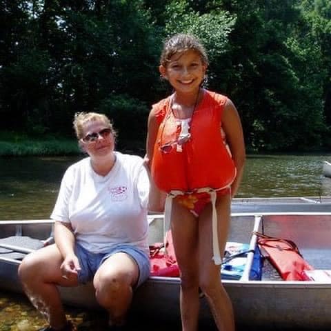 Childhood photo of Ashley and her mom at in front of a kayak