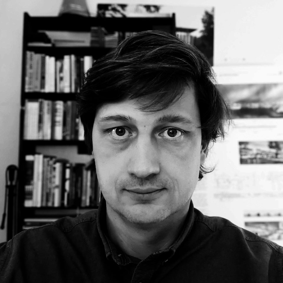 A smiling woman writing on a piece of paper in her home