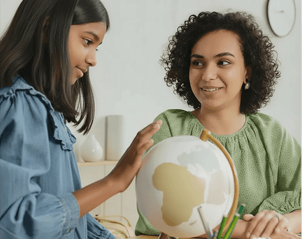 A teacher is showing a globe to a student