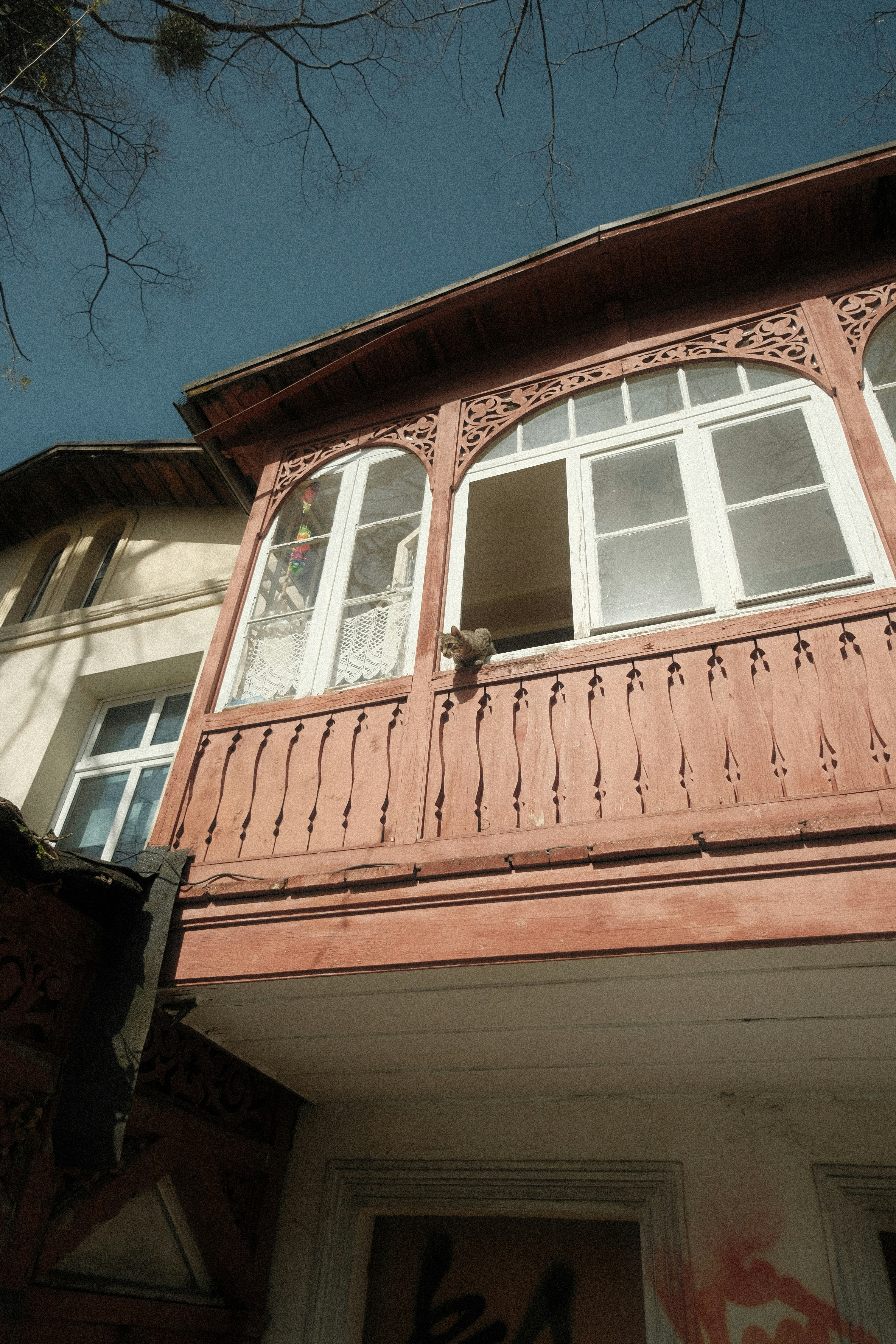 a building with a balcony and a cat sitting on the balcony