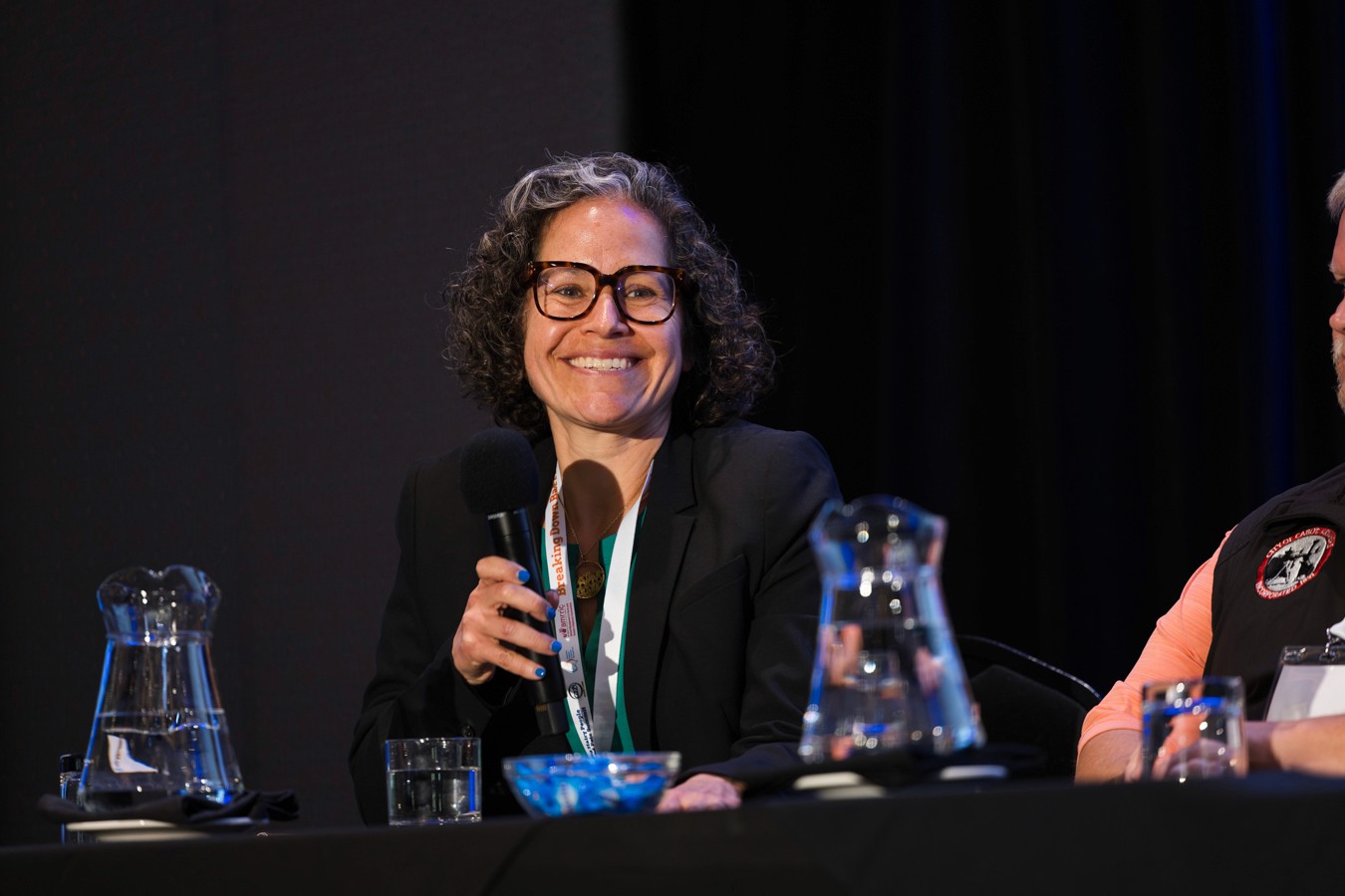 Female panelist speaking into microphone at conferece