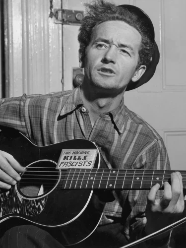 Woody Guthrie playing the guitar. Photo courtesy of the Library of Congress, Washington.