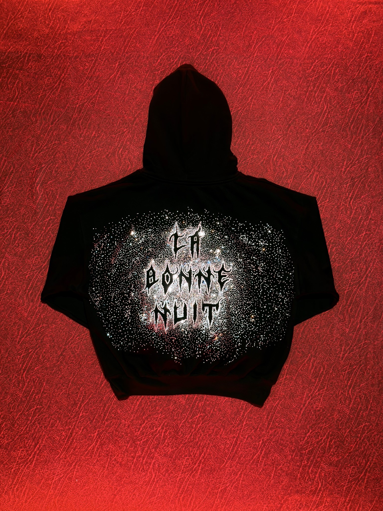 Black hoodie with the words "La Bonne Nuit" on the back in a space-themed design. 