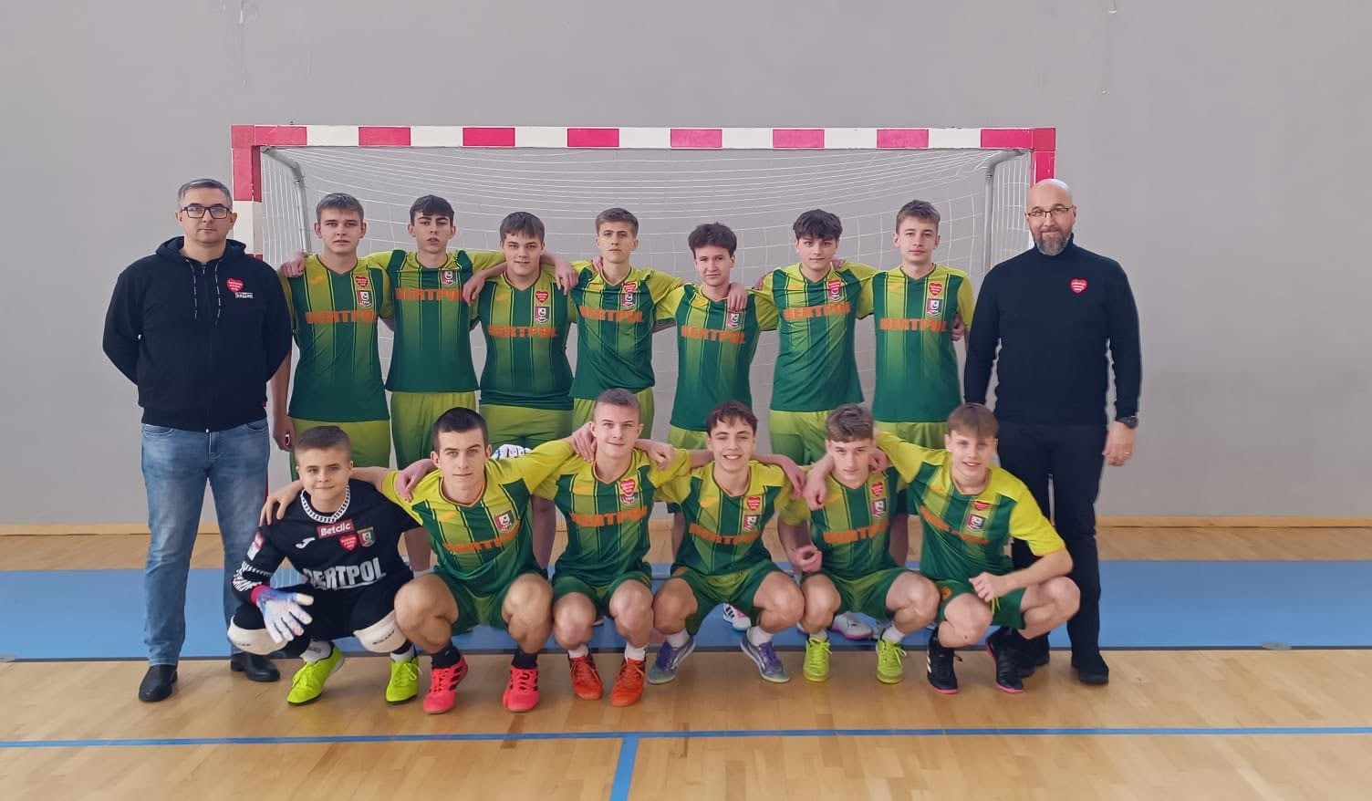 A woman with red hair in a lavender coat and scarf poses against a neutral background, showcasing a stylish and elegant look.