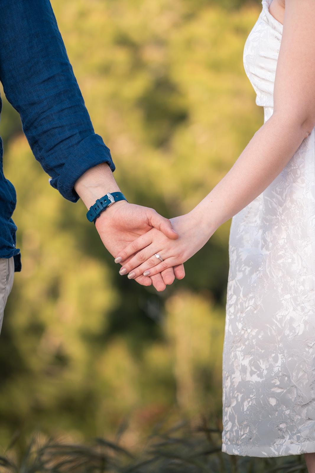 An elegant wedding ceremony setup features a domed gazebo adorned with peach and pink floral arrangements and lush greenery. White chairs line the aisle.