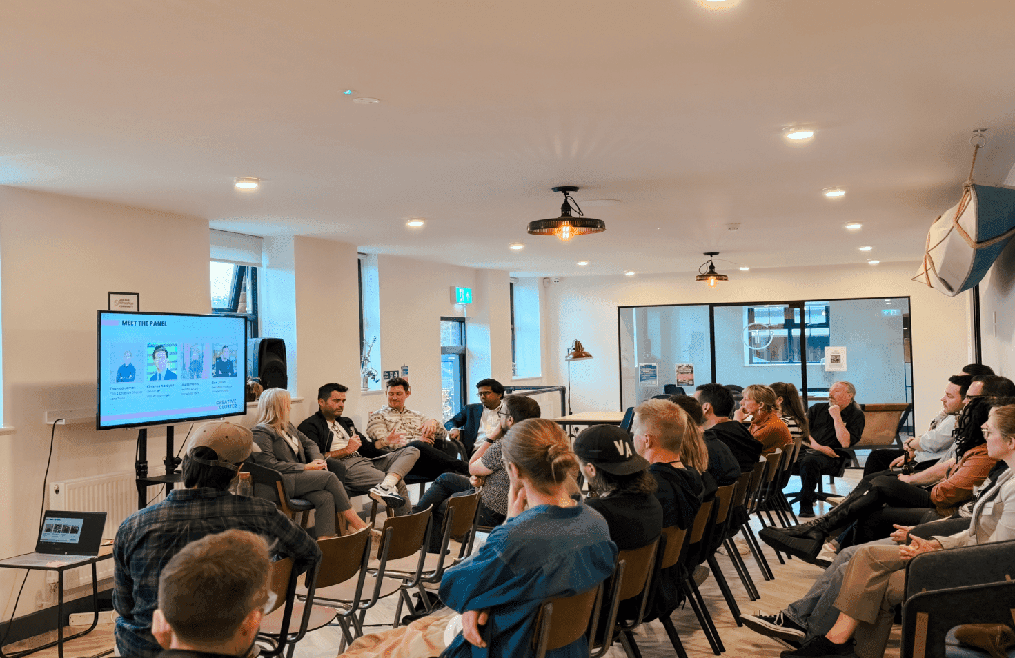 People sitting in a room watching an event.