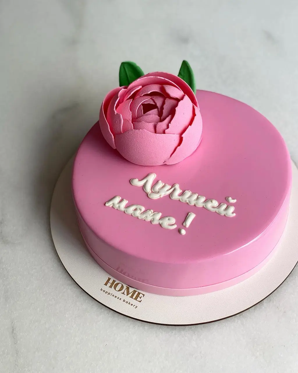 Pink heart-shaped cake with peony flower and "Herzlich Willkommen" message