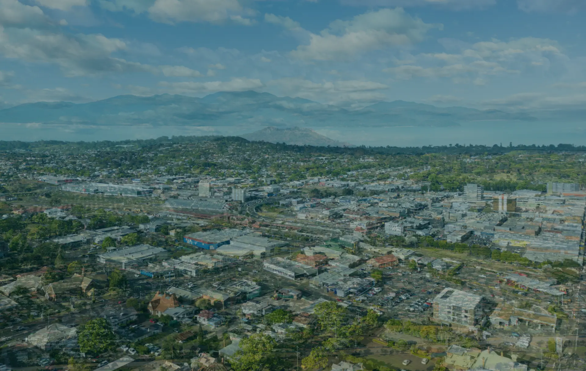 Aerial view of a city with mountains and water in the background