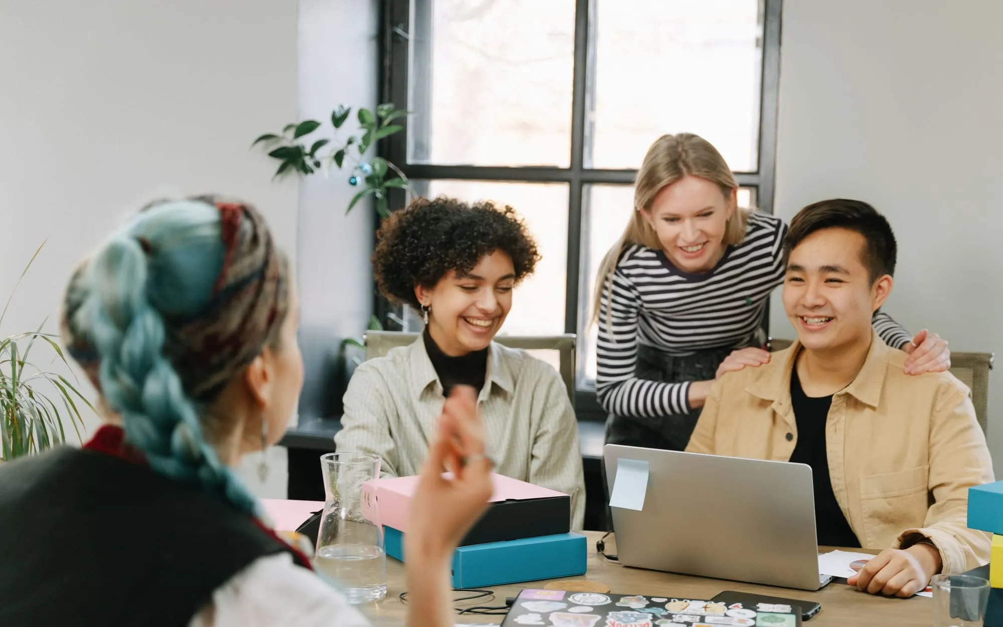 Colleagues working together around a desk in a bright office