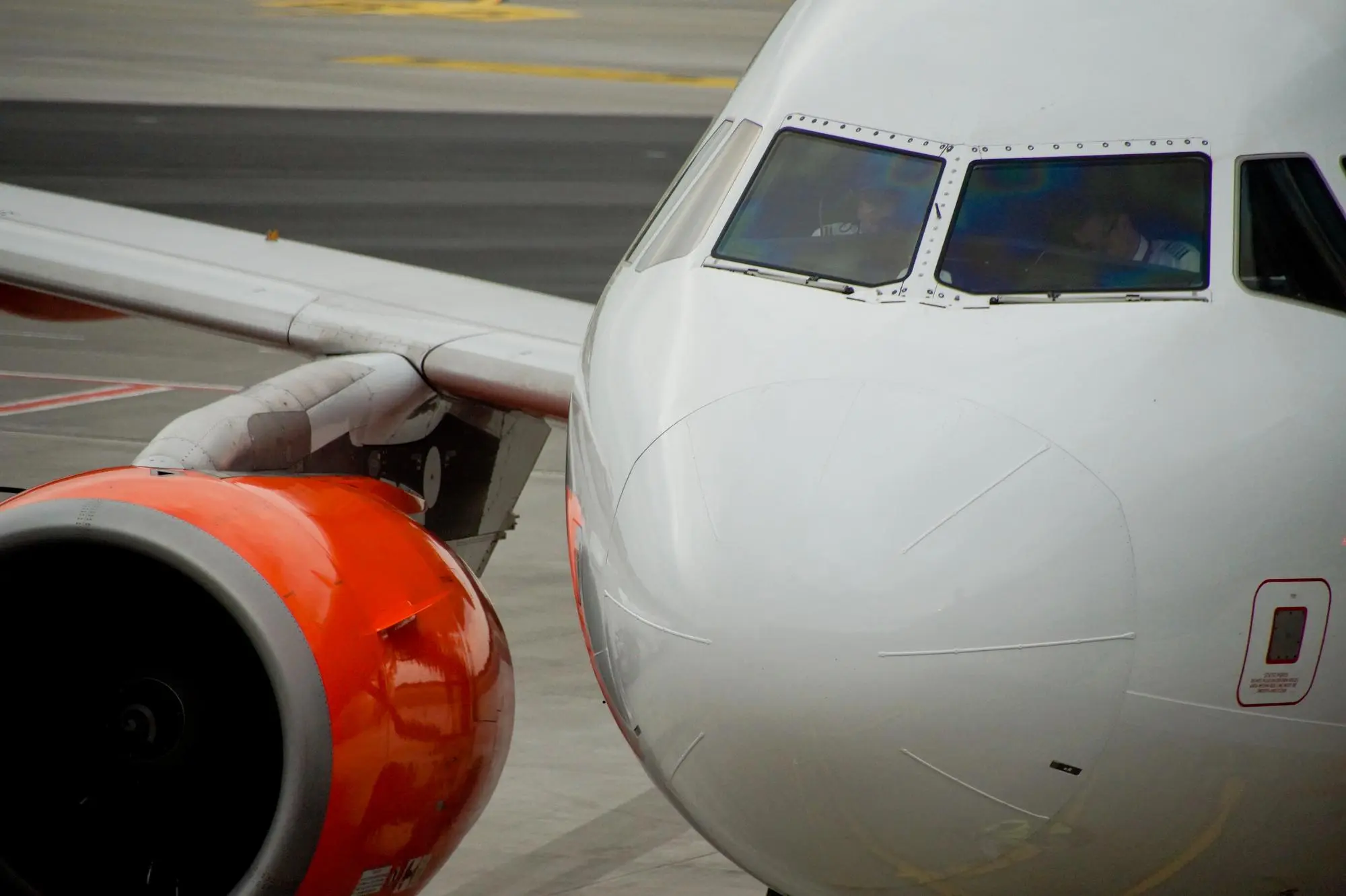 Netted air cargo pallet staged on the tarmac beside an aircraft at sunrise