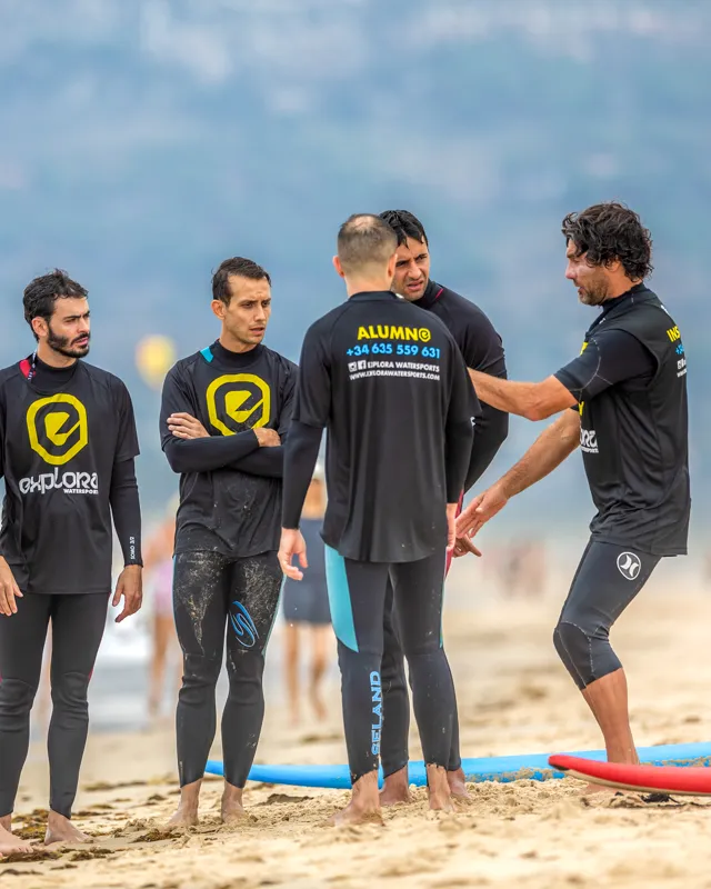 Instructores de surf guiando a principiantes en la playa de Explora Watersports Tarifa. Aprende a surfear con expertos en un ambiente seguro y divertido.