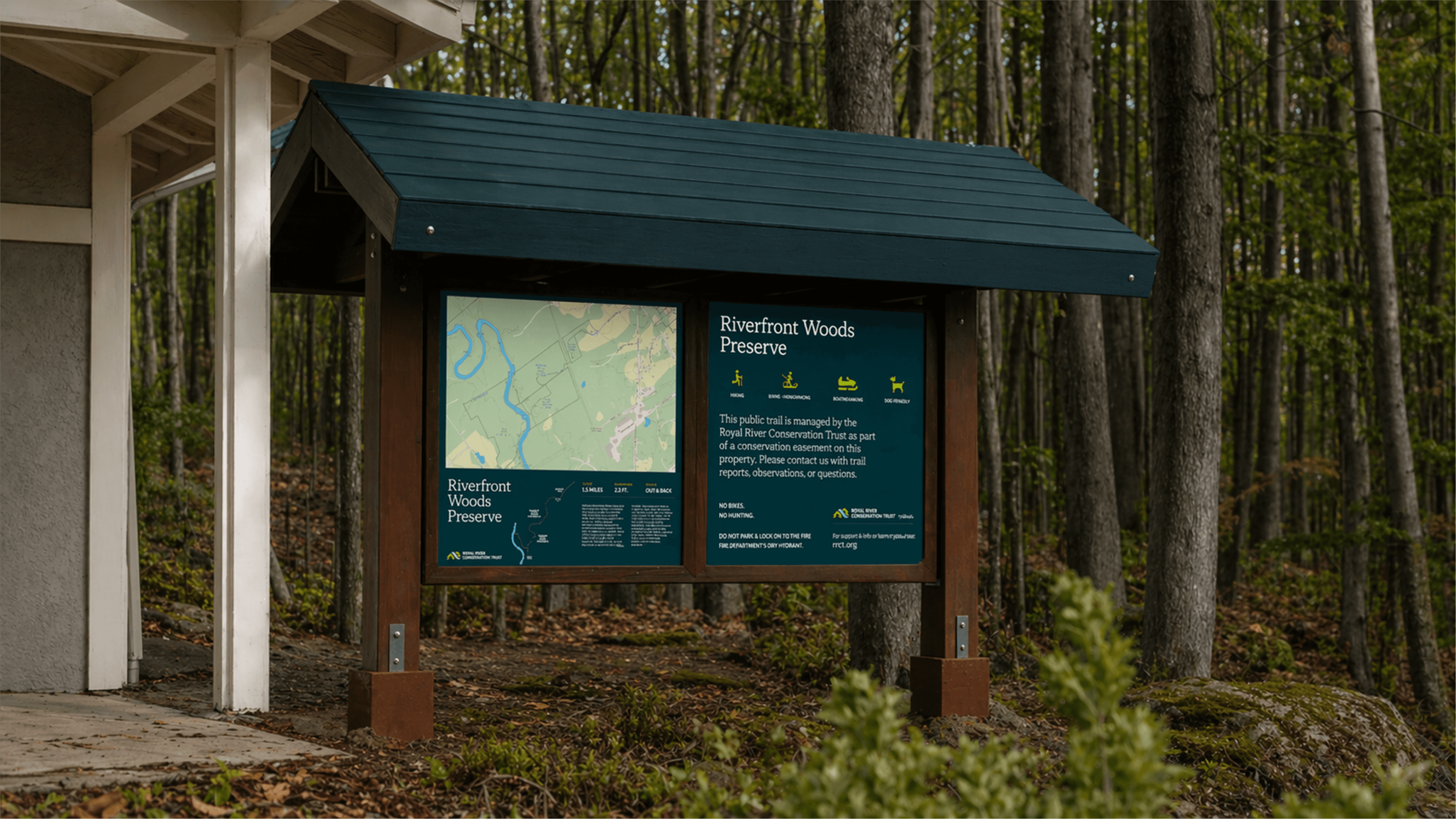 Trailhead signage for Riverfront Woods Preserve with map and visitor information in forest setting