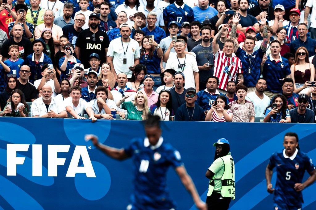 Jules Koundé runs along the touchline as Iraq fans pack the stands at the 2026 FIFA World Cup