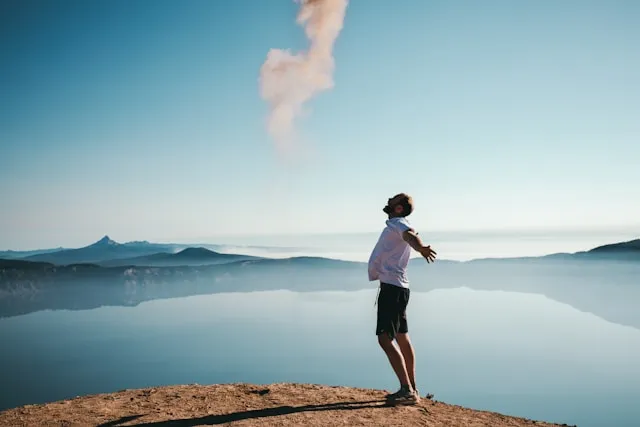 Person standing outdoors near the water at sunrise