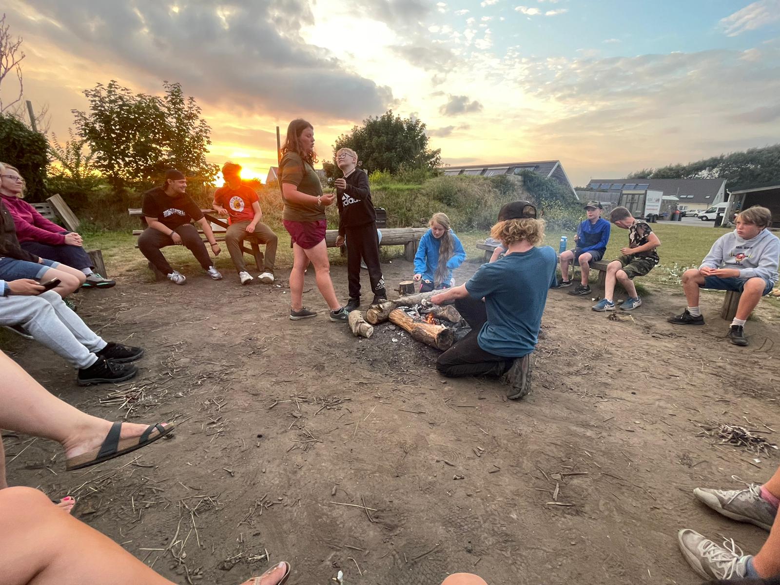 Young people grouped around a campfire