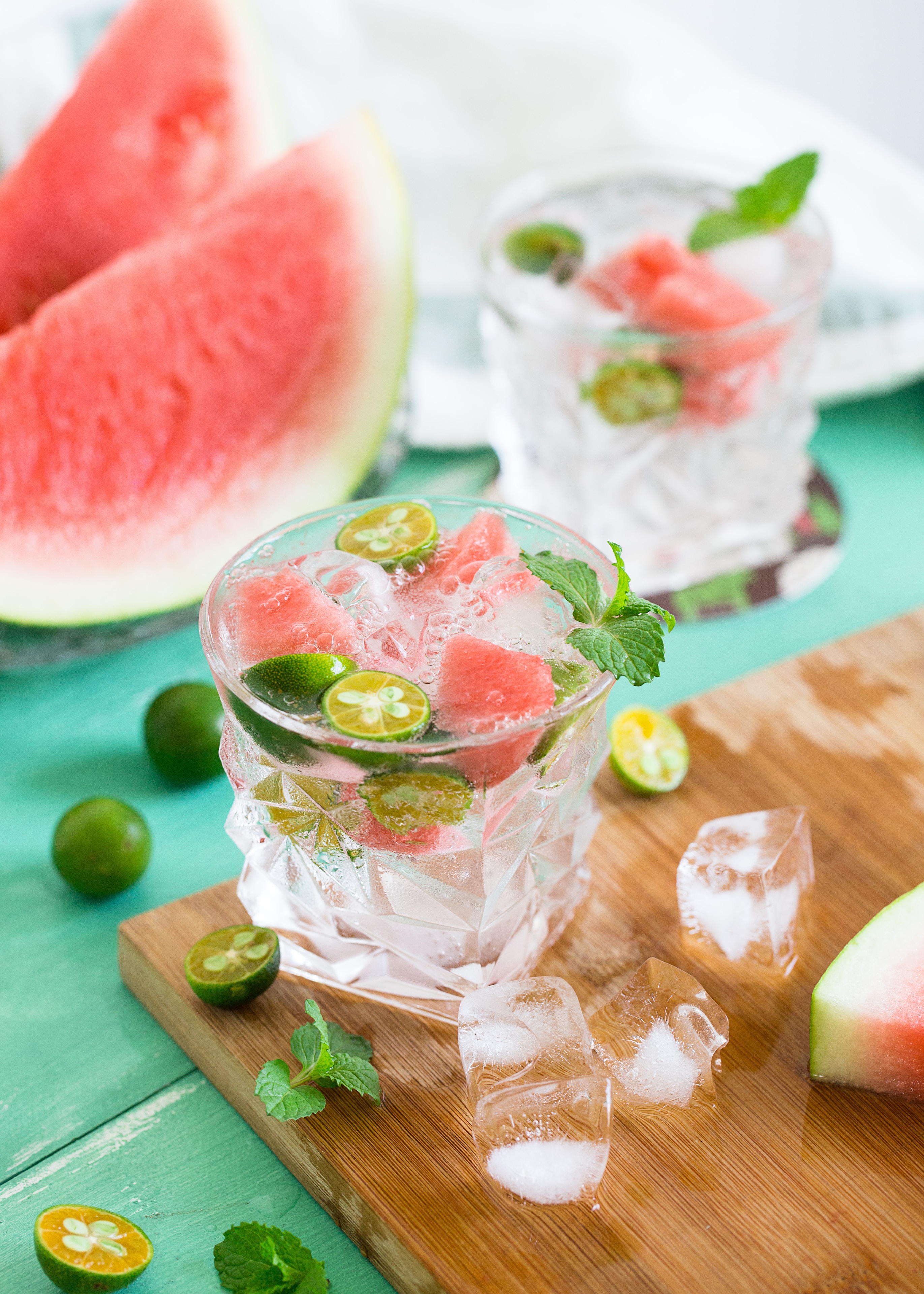 A refreshing cocktail drink that includes limes, watermelon, and sparkling water.