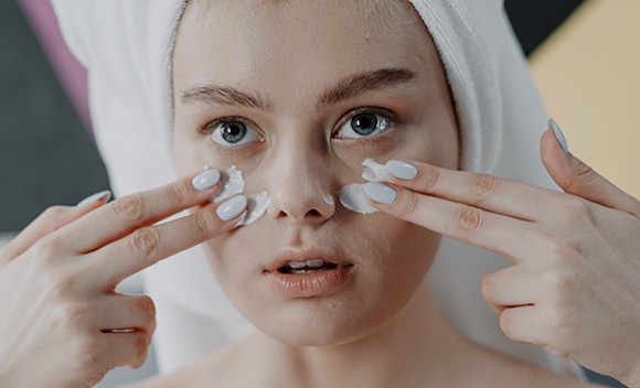 Mujer aplicacion crema rostro